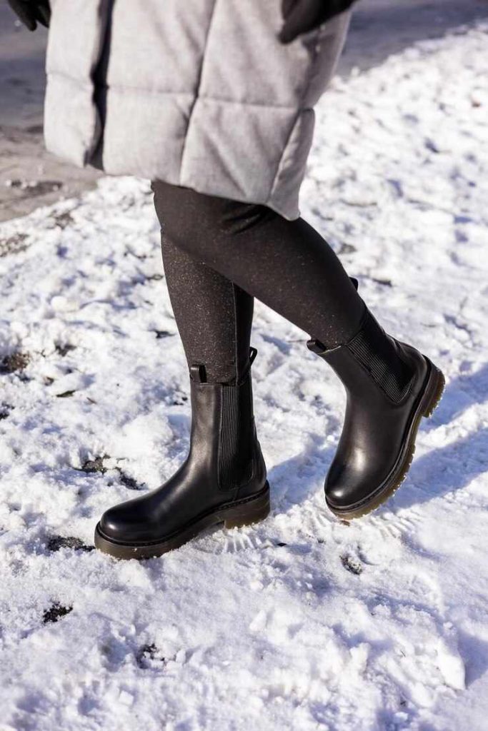 场景图-Woman in fashionable black boots on white snow-1